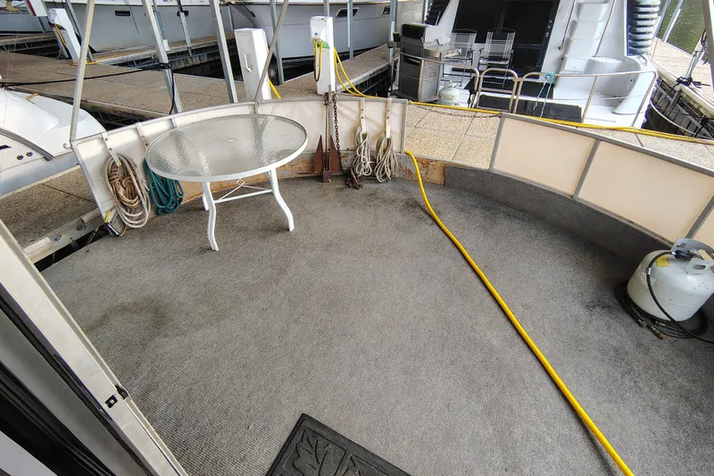 Slide: The Image of Outdoor deck of 1981 Lazy Days 50 boat with table, ropes, and propane tank. - 20