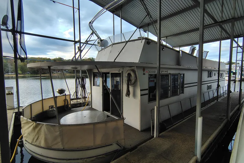 Slide: The Image of 1981 Lazy Days 50 houseboat docked under a covered marina, with scenic lake view. - 3