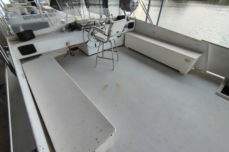 Slide: The Image of 1981 Lazy Days 50 boat deck with steering wheel and seating, docked by the water. - 31