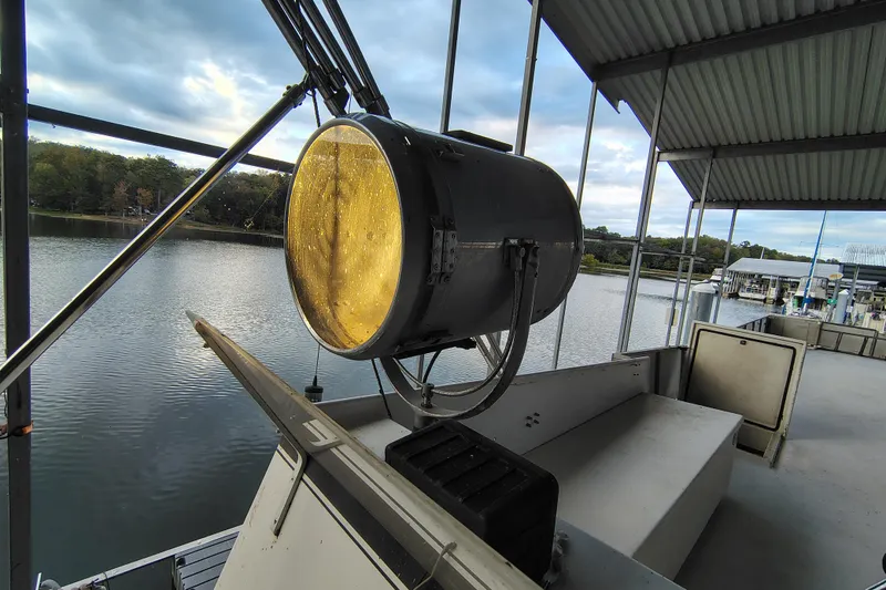 Slide: The Image of Large spotlight on 1981 Lazy Days 50 boat docked by a serene lake. - 36