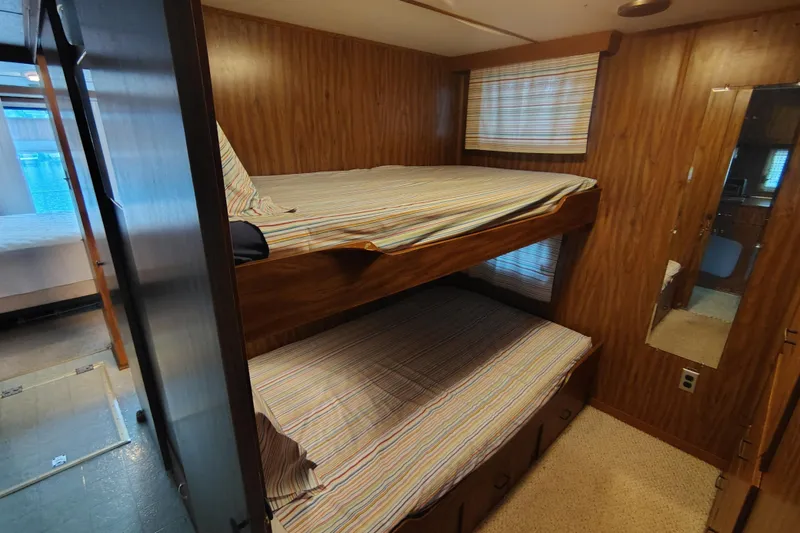 Slide: The Image of Bunk beds in a 1981 Lazy Days 50 RV with wood paneling and striped bedding. - 52