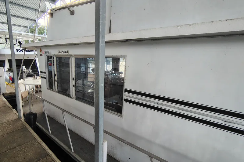 Slide: The Image of 1981 Lazy Days 50 houseboat docked in a marina, side view. - 6