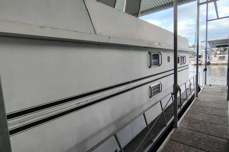 Slide: The Image of 1981 Lazy Days 50 houseboat docked at marina, side view with windows and railing. - 7