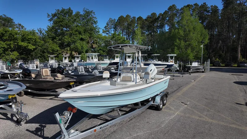 Slide: The Image of 2025 Bulls Bay 2200XS boat on trailer, surrounded by trees and other boats. - 3