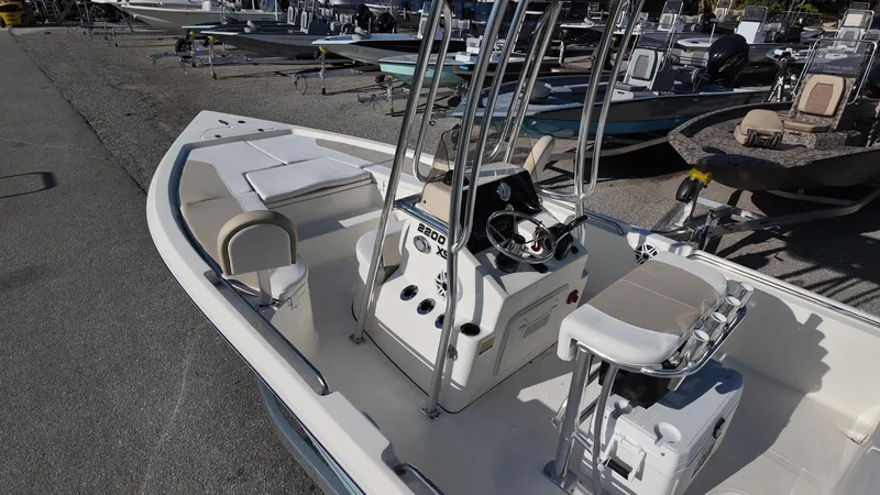 Slide: The Image of 2025 Bulls Bay 2200XS boat with center console and seating, displayed in a marina. - 8