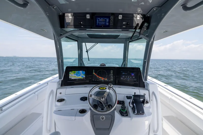 Slide: The Image of Helm of 2026 HCB 42 Lujo boat with advanced navigation systems on open water. - 11
