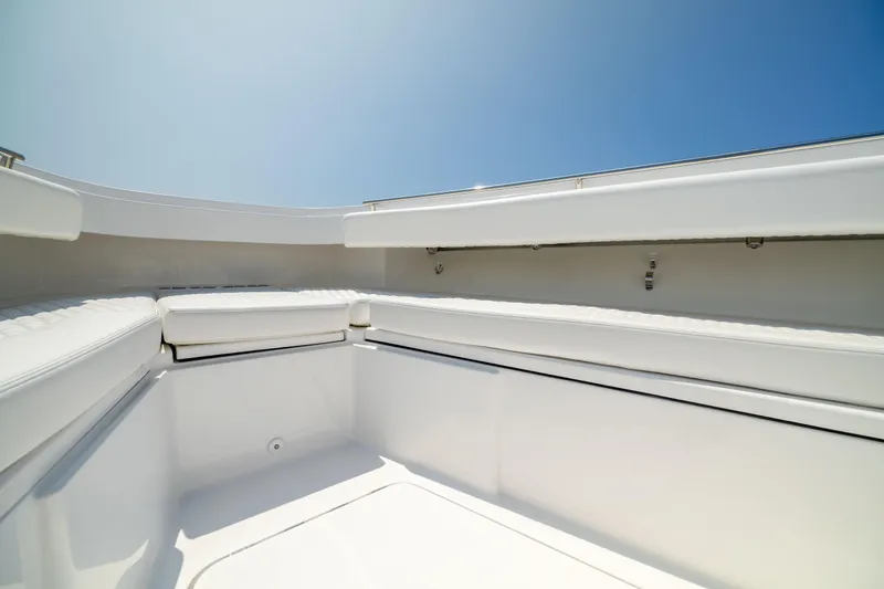 Slide: The Image of 2026 HCB 42 Lujo boat interior with white seating under clear blue sky. - 27