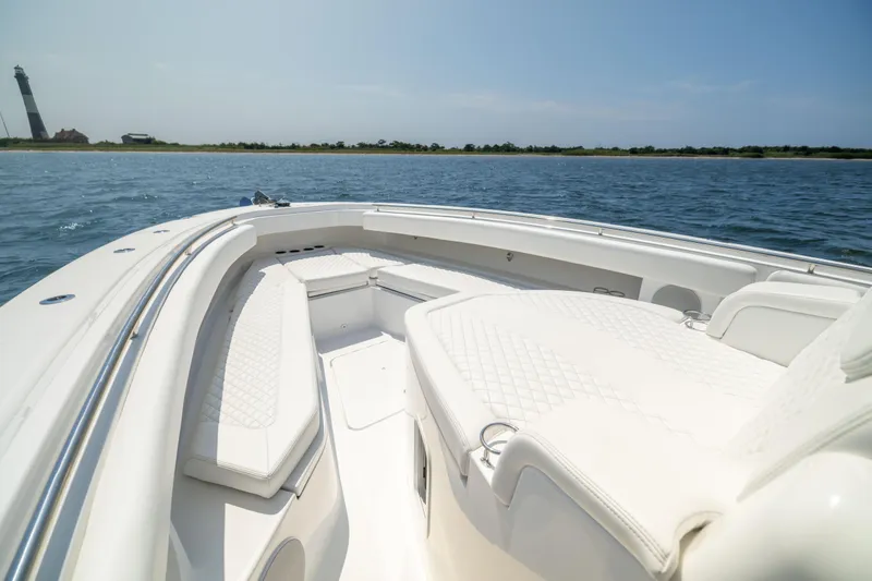 Slide: The Image of Luxurious 2026 HCB 42 Lujo boat interior with white seating, near a lighthouse. - 28