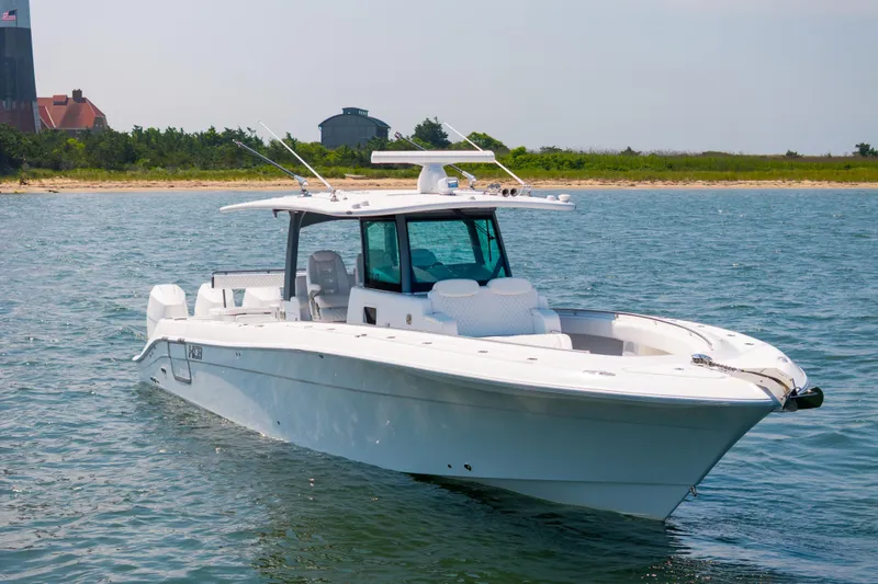 Slide: The Image of 2026 HCB 42 Lujo boat on calm water near a sandy shoreline. - 5