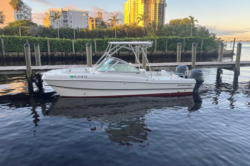 Slide: The Image of 2016 Carolina Cat 230 DC boat docked in a marina with scenic background. - 0