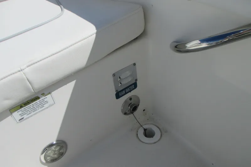 Slide: The Image of 2016 Carolina Cat 230 DC boat interior with raw water access and warning label. - 12