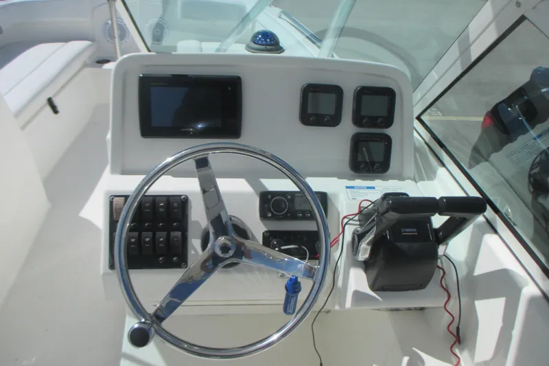 Slide: The Image of 2016 Carolina Cat 230 DC boat dashboard with steering wheel and control panel. - 15