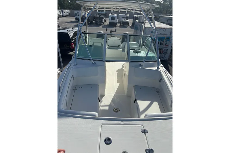 Slide: The Image of 2016 Carolina Cat 230 DC boat interior with seating and windshield, parked outdoors. - 18