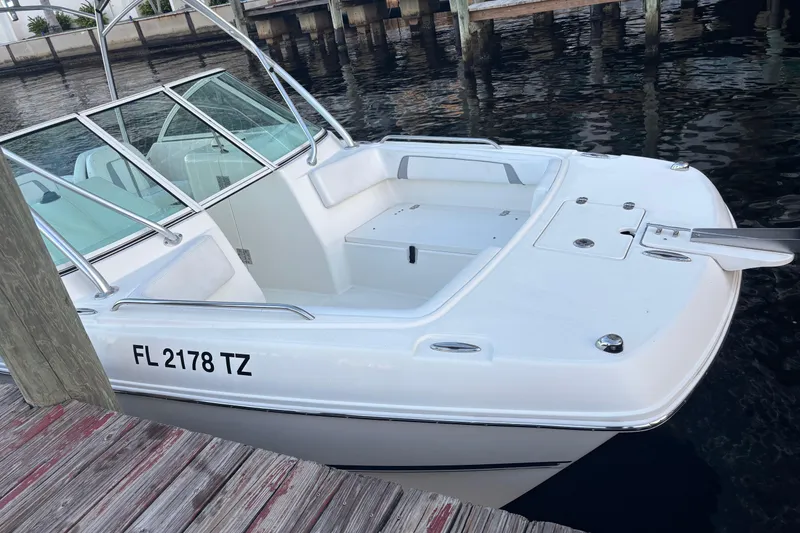 Slide: The Image of 2016 Carolina Cat 230 DC boat docked, featuring sleek design and registration number FL 2178 TZ. - 4
