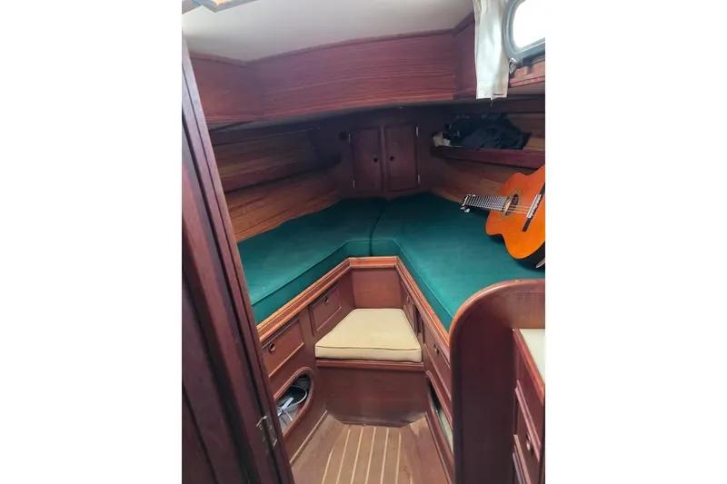 Slide: The Image of 1981 Cape Dory 36 sailboat cabin with green cushions and a guitar. - 10