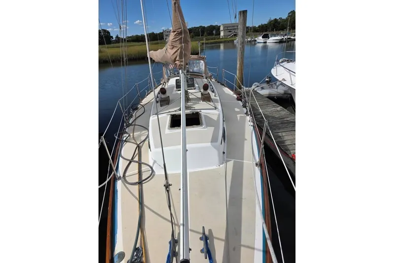 Slide: The Image of 1981 Cape Dory 36 sailboat docked, showcasing deck and rigging in a serene marina setting. - 11