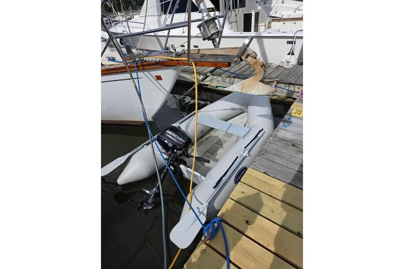 Slide: The Image of Inflatable dinghy with Mercury outboard motor docked beside 1981 Cape Dory 36 sailboat. - 12