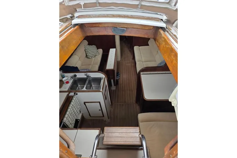 Slide: The Image of Interior of 1981 Cape Dory 36 sailboat with cozy seating and compact kitchen area. - 13
