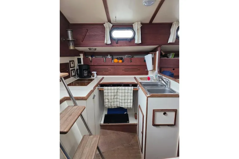 Slide: The Image of Interior of 1981 Cape Dory 36 sailboat galley with wooden accents and compact kitchen setup. - 14