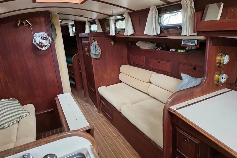 Slide: The Image of Interior of 1981 Cape Dory 36 sailboat with wooden furnishings and beige seating. - 8