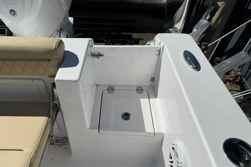 Slide: The Image of 2026 Sportsman Open 232 Center Console boat interior with beige seating and storage compartment. - 13