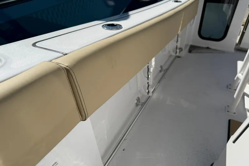 Slide: The Image of 2026 Sportsman Open 232 Center Console boat interior with beige cushioned seating. - 14
