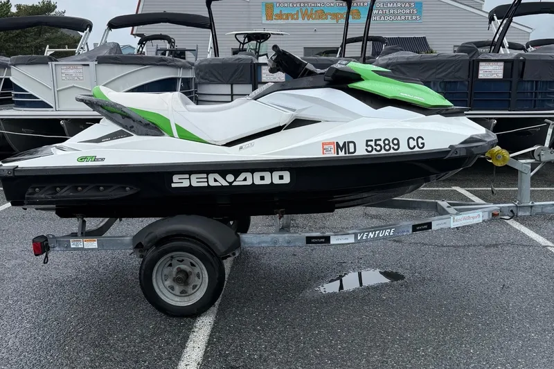 Slide: The Image of 2013 Sea-Doo GTI 130 jet ski on trailer in parking lot. - 1
