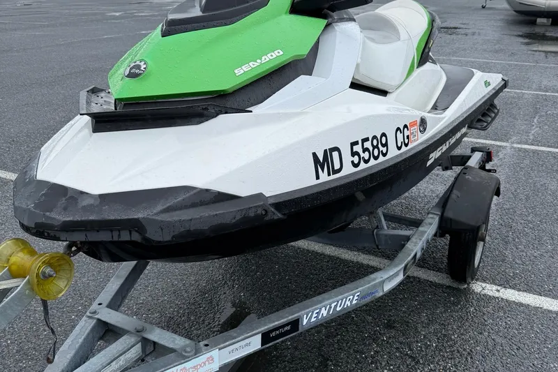 Slide: The Image of 2013 Sea-Doo GTI 130 jet ski on trailer in parking lot. - 4