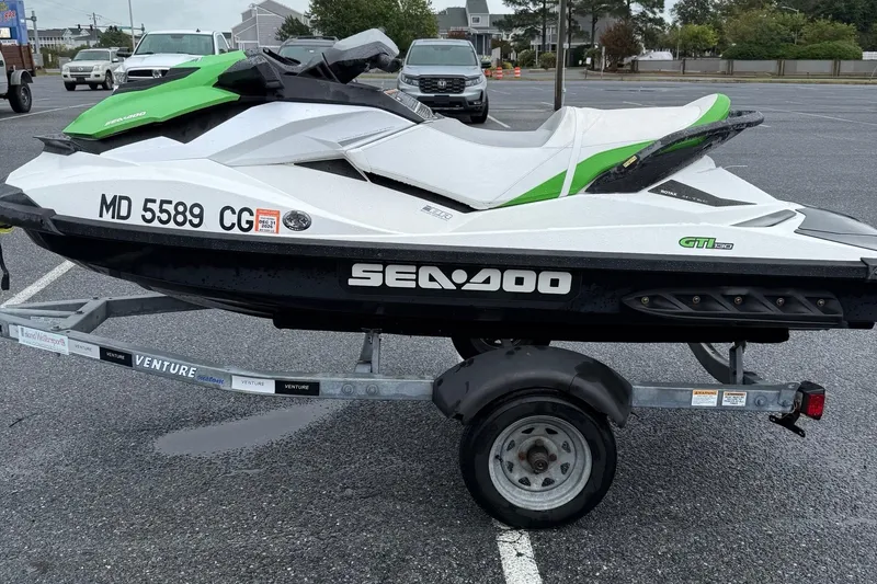 Slide: The Image of 2013 Sea-Doo GTI 130 jet ski on trailer in parking lot. - 5