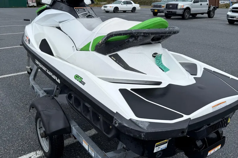 Slide: The Image of 2013 Sea-Doo GTI 130 jet ski on trailer in parking lot. - 6