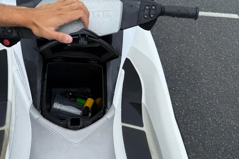 Slide: The Image of 2013 Sea-Doo GTI 130 storage compartment with hand opening lid, showing contents inside. - 9