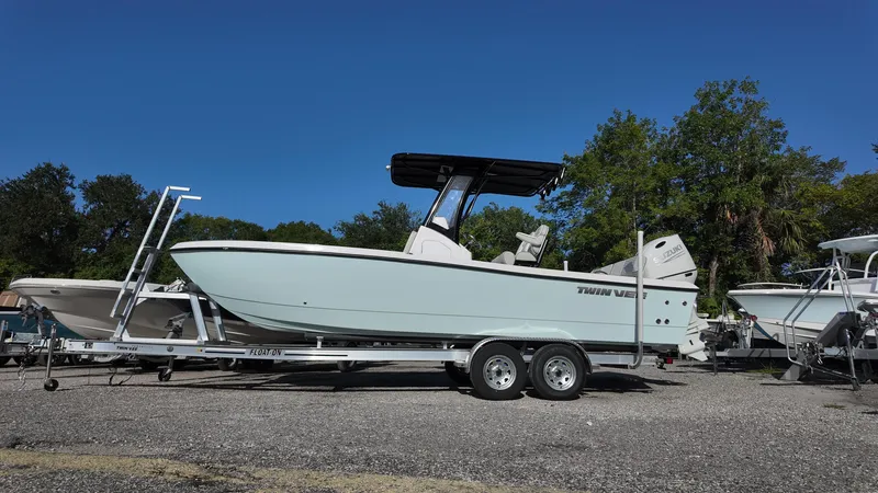 The Image of 2026 Twin Vee 22 Bay Cat boat on trailer, parked outdoors under clear blue sky. - 0