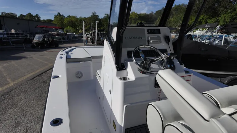 Slide: The Image of 2026 Twin Vee 22 Bay Cat boat interior with steering wheel and Garmin navigation system. - 10