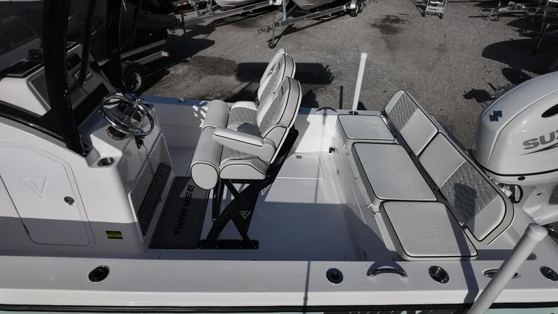 Slide: The Image of 2026 Twin Vee 22 Bay Cat boat interior with seating and steering wheel. - 11