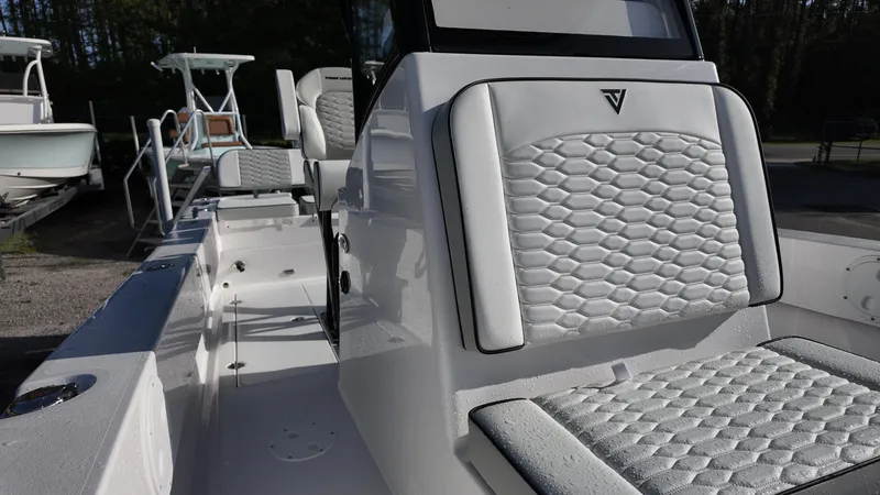 Slide: The Image of 2026 Twin Vee 22 Bay Cat boat interior with white cushioned seating and sleek design. - 16