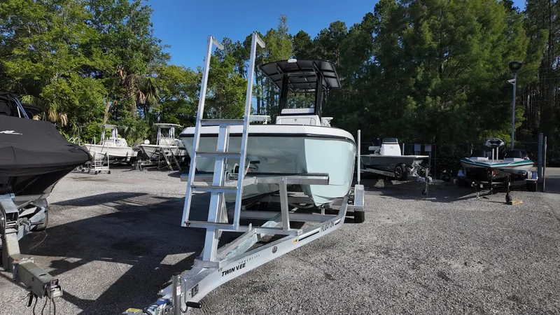 Slide: The Image of 2026 Twin Vee 22 Bay Cat boat on trailer in outdoor lot with trees. - 6