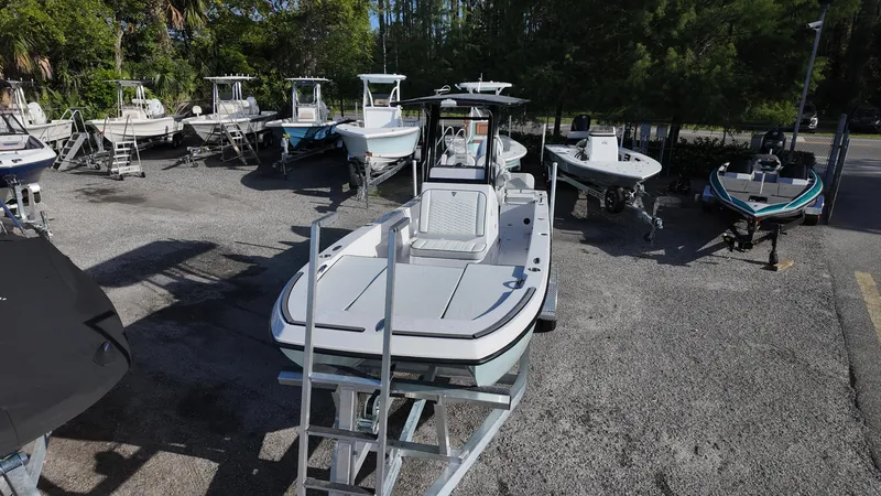 Slide: The Image of 2026 Twin Vee 22 Bay Cat boat displayed in a marina with other boats. - 7