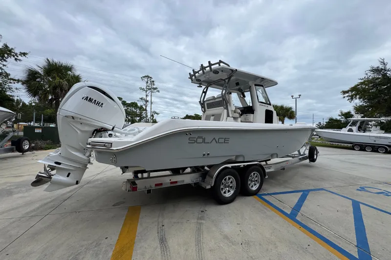Slide: The Image of 2026 Solace 28 HCS boat on trailer with Yamaha engine, parked outdoors. - 10