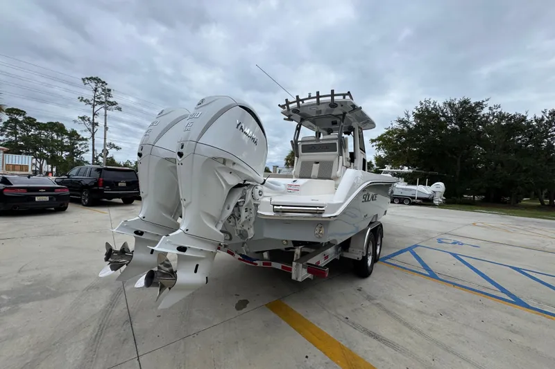 Slide: The Image of 2026 Solace 28 HCS boat with dual Yamaha outboard engines in a parking lot. - 11