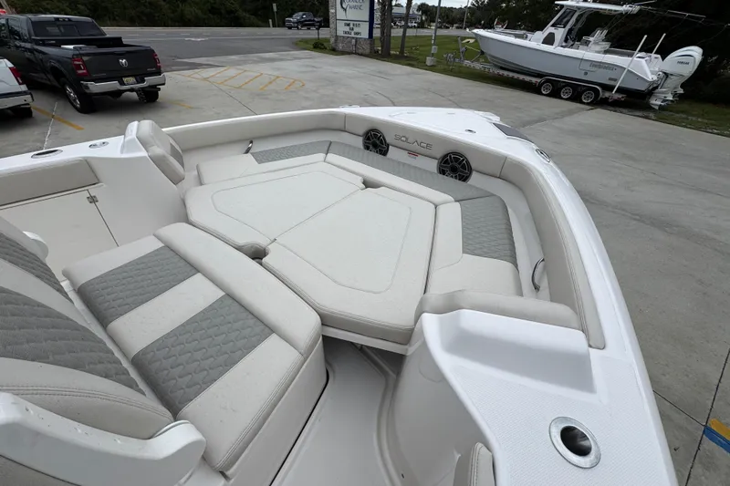 Slide: The Image of 2026 Solace 28 HCS boat with spacious seating and modern design in a parking lot. - 16