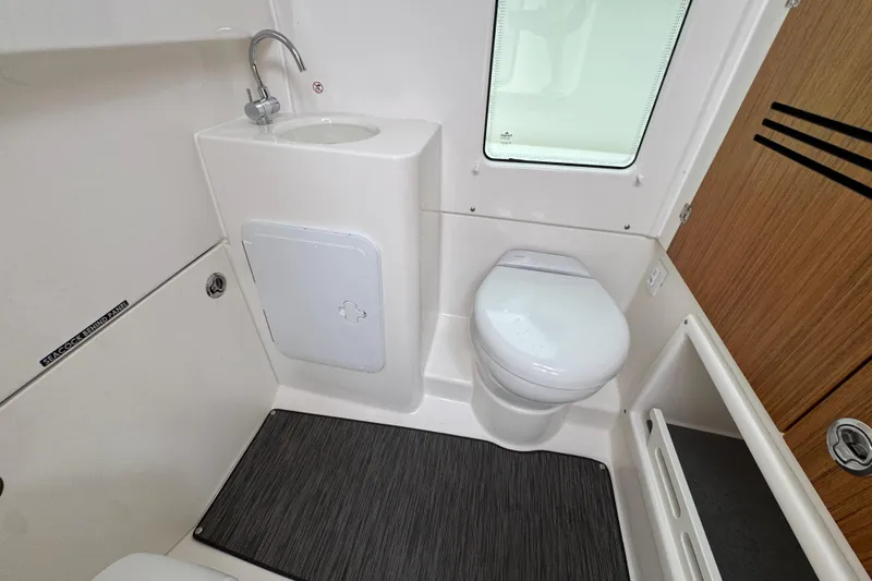 Slide: The Image of 2026 Solace 28 HCS bathroom interior with toilet, sink, and window. - 24