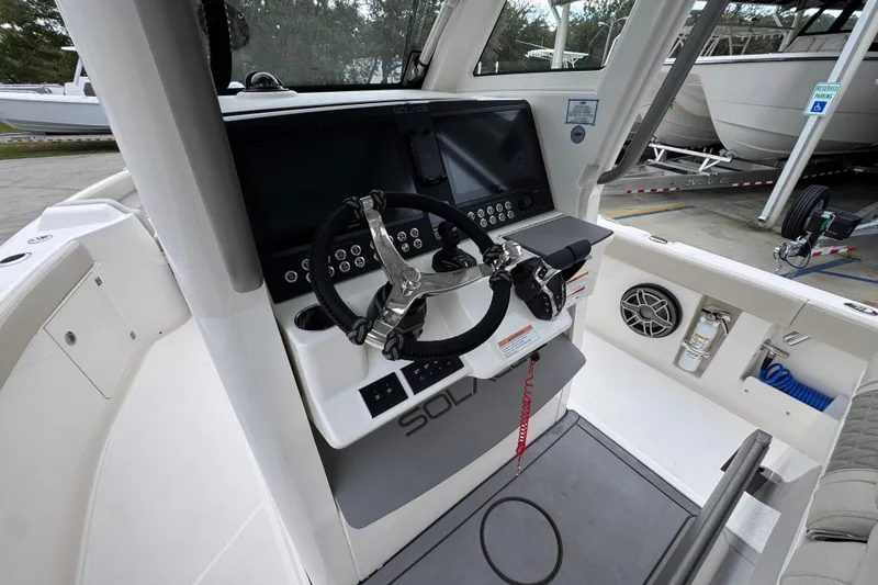 Slide: The Image of 2026 Solace 28 HCS boat helm with steering wheel, controls, and display screen. - 30
