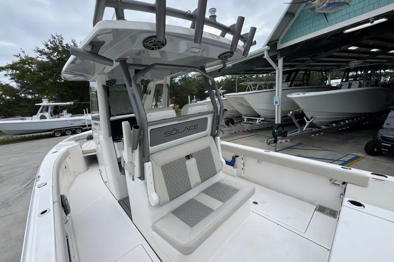 Slide: The Image of 2026 Solace 28 HCS boat interior, featuring sleek seating and modern design in a marina setting. - 35