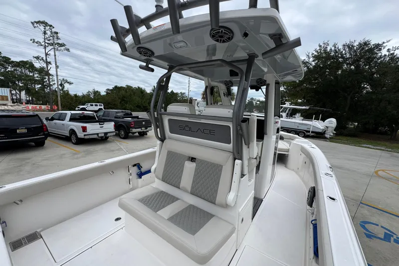 Slide: The Image of 2026 Solace 28 HCS boat interior with seating and rod holders in a parking lot. - 37