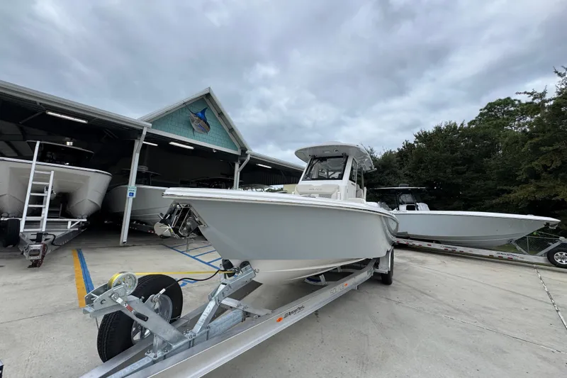 Slide: The Image of 2026 Solace 28 HCS boat on trailer at marina, cloudy sky background. - 4