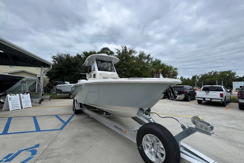 Slide: The Image of 2026 Solace 28 HCS boat on trailer in parking lot under cloudy sky. - 6