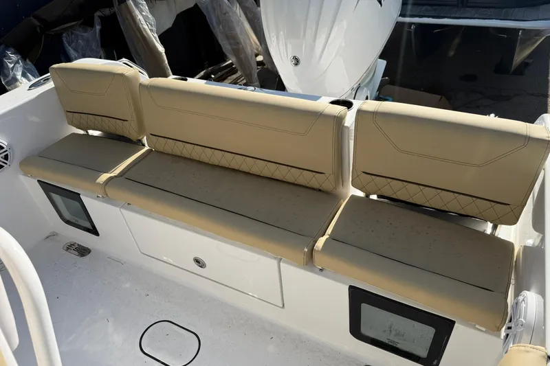 Slide: The Image of 2026 Sportsman Heritage 231 Center Console boat with beige cushioned seating. - 14