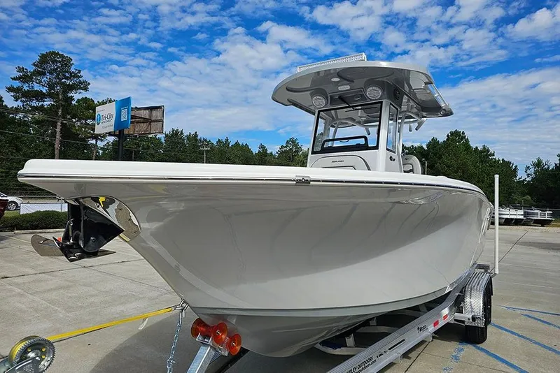 Slide: The Image of 2026 Sea Pro 262 Offshore boat on trailer, under a clear blue sky. - 6