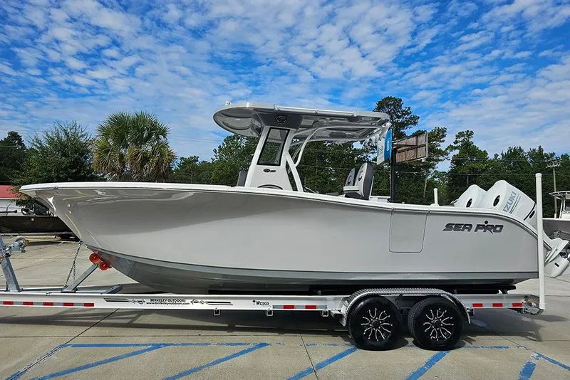 Slide: The Image of 2026 Sea Pro 262 Offshore boat on trailer, under a clear blue sky. - 7