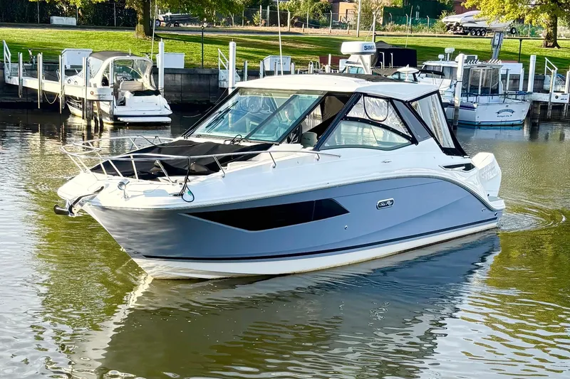 Slide: The Image of 2025 Sea Ray Sundancer 320 Outboard boat docked in a serene marina setting. - 1